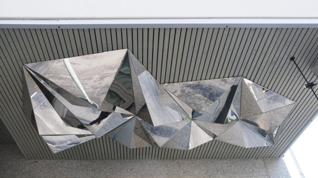 Milla Vuorinen: Porigami, 2020. Kuva: Milla Vuorinen Peilipintainen monisivuinen origamia muistuttava veistos katoksen sisäpinnalla.